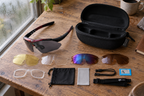 Fahrradbrille mit Wechselgläsern – mit Etui und Gläsern auf einem Holztisch