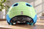 Kinderhelm Grün/Blau – Rückansicht mit Einstellrad auf einem Tisch