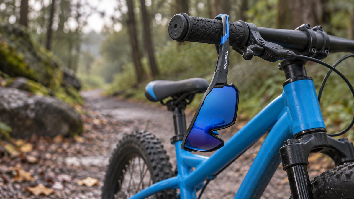 Kinder-Sportbrille Schwarz/Blau – am Lenker eines Kinderfahrrads auf einem Waldweg