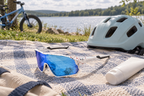 Kinder-Fahrradbrille – neben einem Helm auf einer Picknickdecke