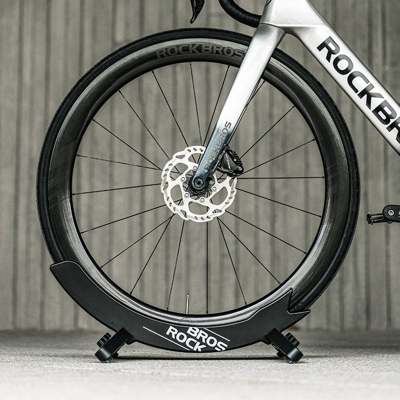 Ein Rennrad im Ständer vor dunklem Hintergrund.