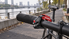 Fahrradklingel Schwarz/Rot – am Lenker eines Fahrrads am Fluss