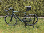 Die Tasche an einem weißen Rennrad von der Seite.